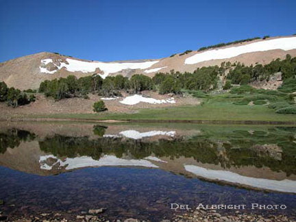 Lake reflection of snow, mountains and sky in high Sierra Nevada Mountains
