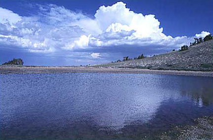 Clouds reflecting in lake in high mountains of the Sweetwater Mountains