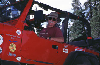 Del Albright in Jeep with big smile on trail