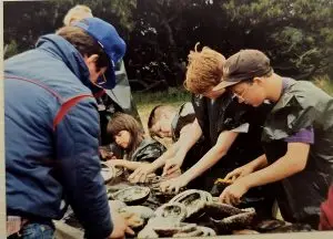 Kids in black plastic bags cleaning abalone